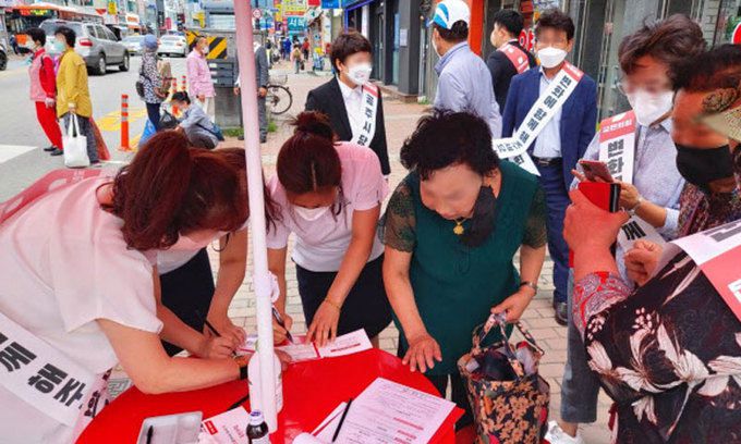 최근 충남 공주의 국민의힘 홍보 부스에서 시민들이 국민의힘 입당원서를 작성하고 있다. 연합뉴스