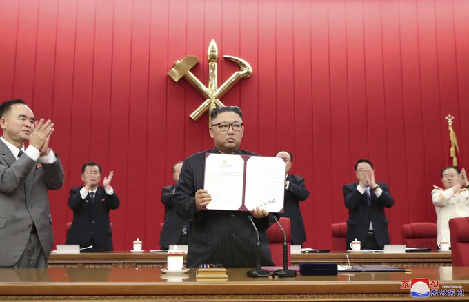 김정은 북한 노동당 총비서가 17일 당 중앙위원회 제8기 제3차 전원회의에서 자신이 서명한 문서를 들어보이고 있다. 조선중앙통신·AP통신