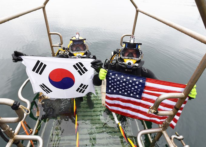 6월 15일 경남 창원 진해만 일대에서 진행된 한미 연합 구조전훈련에서 양국 구조대원들이 손상함정 긴급 복구훈련 종료 후 자국 국기를 펼치며 한미동맹 의지를 표출하고 있다. 해군 제공