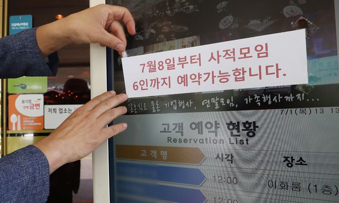 1일 서울의 한 식당에서 직원이 예약 현황판에 오는 8일부터 6인까지 예약이 가능하다는 안내문을 붙이고 있다. 뉴스1