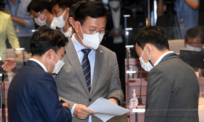 송영길 더불어민주당 대표가 지난 7일 서울 여의도 국회 예결위회의장에서 열린 정책의원총회에서 윤관석 의원, 김용민 최고위원과 자료를 살펴보고 있다. 뉴스1