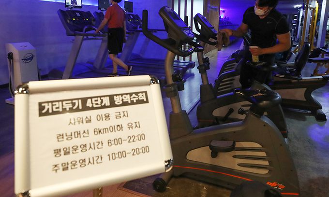 사회적 거리두기 4단계 첫날인 지난 12일 서울 은평구 연신내 한 헬스장에서 관계자가 런닝머신 등 기구 방역을 하고 있다. 뉴시스