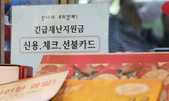 지난 13일 서울의 한 전통시장에 붙은 재난지원금 안내 문구. 뉴스1