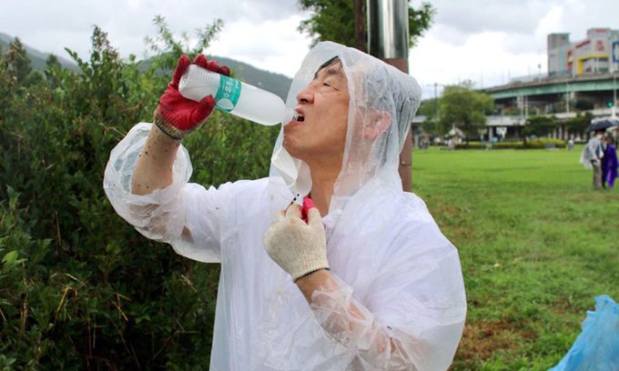 최재형 전 감사원장이 지난 17일 부산 해운대구 동천교 인근에서 국민의힘 김미애 의원 등과 환경미화 봉사활동을 하던 중 물을 마시고 있다. 김미애 의원실 제공