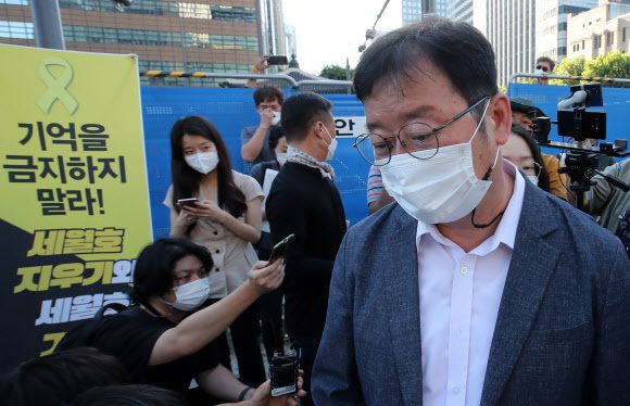 서울시가 광화문 광장 재구조화 공사를 위해 광장에 있는 '세월호 기억공간' 철거를 예고한 26일 오전, 세월호 기억공간 입구에서 서울시 김혁 총무과장(앞)이 김선우 4·16연대 사무처장에게 철거와 관련한 입장을 전달한 뒤 돌아서고 있다. 연합뉴스