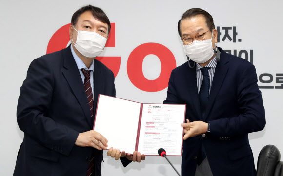 윤석열 대선 예비후보가 30일 오후 서울 여의도 국민의힘 중앙당 당사를 방문해 대외협력위원장인 권영세 의원에게 입당원서를 제출하고 있다. 뉴시스