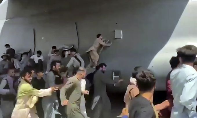 지난 16일(현지시간) 아프가니스탄 카불의 하미드 카르자이 국제 공항에서 활주로를 따라 이동하는 미 공군 C-17 수송기에 아프간 사람들이 매달리고 있다. 카불=AP뉴시스
