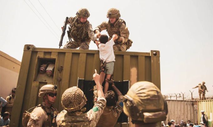 미군 장병들이 아프가니스탄에서 탈출하려는 어린이 등 난민을 보살피는 모습. 미 국방부 홈페이지