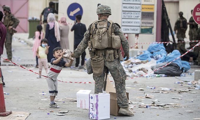 탈레반이 장악한 아프가니스탄에서 미국인 등의 대피 작전을 돕기 위해 수도 카불의 하미드 카르자이 국제공항에 배치된 미국 해병대원이 지난 20일(현지시간) 한 아프간 어린이에게 전투식량을 건네고 있다. 카불=AP연합뉴스