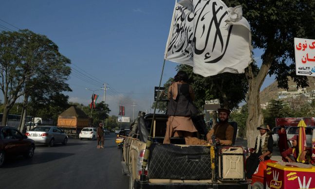 아프가니스탄을 점령한 이슬람 무장조직 탈레반 대원들이 22일(현지시간) 자신들을 상징하는 깃발이 꽂힌 차량을 타고 수도 카불 시내를 순찰하고 있다. AFP=연합뉴스