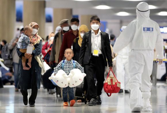아프가니스탄 협력자와 그 가족이 지난 26일 오후 공군 다목적 공중급유 수송기를 이용해 인천공항에 도착한 뒤 임시 방역시설로 가기 위해 버스로 이동하고 있다. 인천공항=연합뉴스
