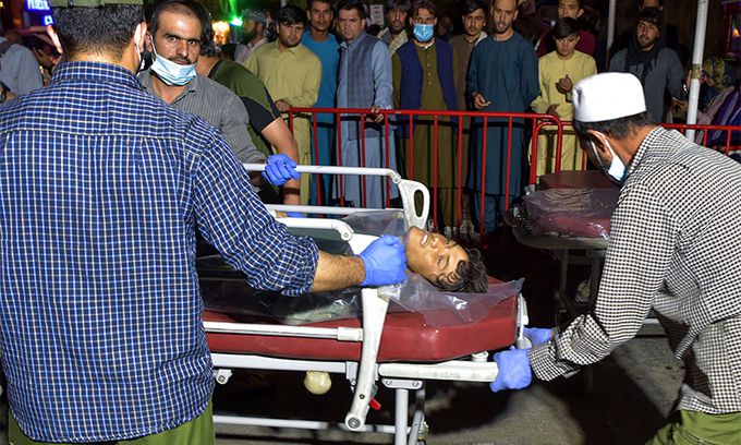 26일(현지시간) 의료진과 자원봉사자들이 아프가니스탄 카불 공항 밖에서 발생한 테러로 다친 시민을 들것에 옮겨 병원으로 이송하고 있다. AFP연합뉴스