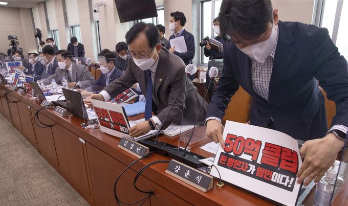 與 “돈 받은 자가 범인” 5일 국회에서 열린 국회 산업통상자원중소벤처기업위원회의 산자부 국정감사에서 더불어민주당 간사인 강훈식 의원(오른쪽) 등 민주당 의원들이 성남 대장동 개발사업 특혜 논란과 관련해 국민의힘 인사 연루 의혹을 강조한 손팻말을 내걸고 있다. 서상배 선임기자