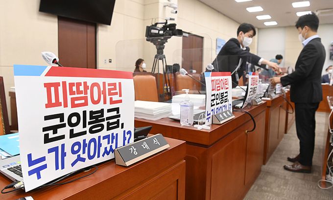 15일 서울 여의도 국회에서 열린 국방위원회의 5·18민주화운동 진상규명 조사위원회 등에 대한 국정감사에서 국민의힘 관계자들이 소속 의원 자리에 피켓을 부착하고 있다. 공동취재사진