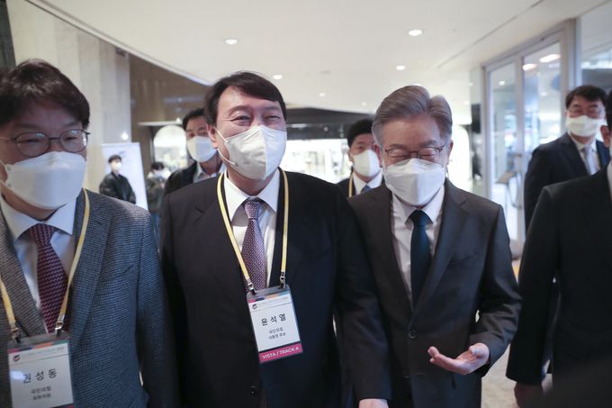 이재명 더불어민주당, 윤석열 국민의힘 대선 후보가 10일 서울 광진구 그랜드 워커힐 서울에서 열린 글로벌인재포럼2021 VIP간담회에서 대화를 나누며 이동하고 있다.    윤석열 캠프 제공