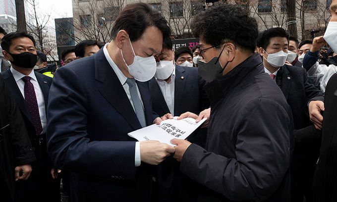 15일 오전 한국노총 간담회를 위해 서울 여의도 한국노총을 찾은 국민의힘 윤석열 대선 후보가 간담회 전 건물 밖에서 기자회견을 하던 한상균 권리찾기유니온 대표를 만나 ‘근로기준법 개정 촉구 입법청원서’를 전달 받고 있다. 뉴스1