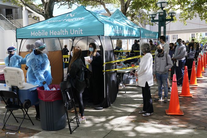 22일(현지시간) 미국 플로리다주 마이애미 도심에 설치된 신종 코로나바이러스 감염증(코로나19) 검사소 앞에 차례를 기다리는 주민들이 길게 줄지어 서 있다. 마이애미 AP=연합뉴스