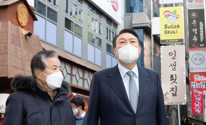 윤석열 국민의힘 대선후보가 2일 오후 서울 종로구 젊음의거리에서 신종 코로나바이러스 감염증(코로나19) 피해 자영업자들과의 간담회에 앞서 강한식 종로구관철동문화발전위원회 회장에게 설명을 듣고 있다.    국회사진취재단