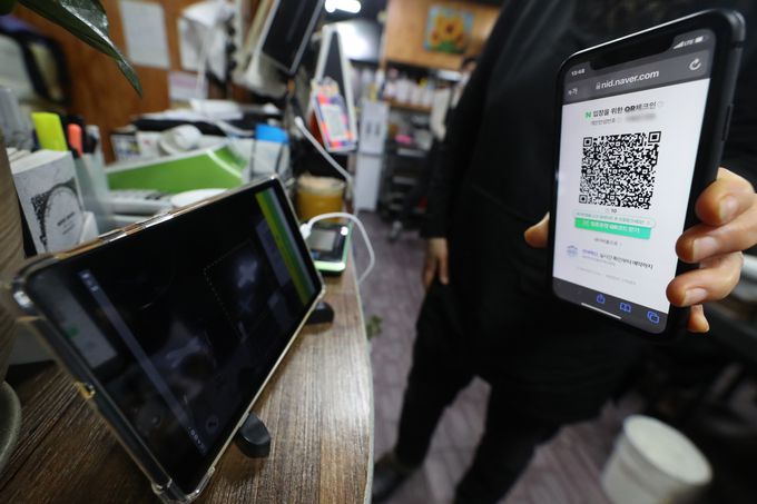 방역패스 집행정지 신청에 대한 심문기일인 7일 오후 서울 성북구의 한 음식점에서 손님이 QR코드 체크인을 하고 있다.   뉴시스