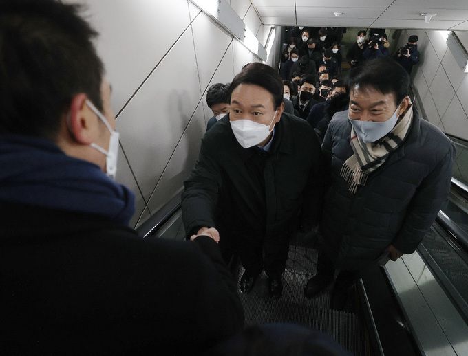 국민의힘 윤석열 대선 후보가 7일 출근길 ‘지옥철’을 체험한 뒤 서울지하철 9호선 국회의사당역에서 에스컬레이터를 타고 올라가며 한 시민과 악수하고 있다. 서상배 선임기자