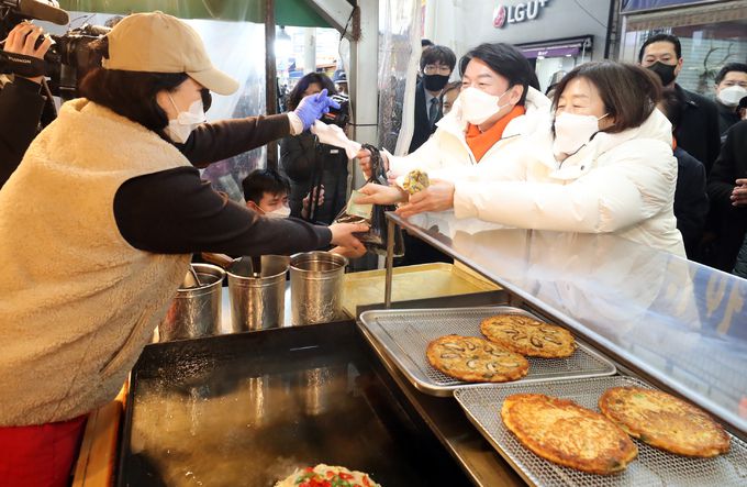 안철수 국민의당 대선 후보와 배우자 김미경씨가 7일 오후 충남 천안중앙시장을 방문해 상인들과 인사를 나눈 뒤 빈대떡을 구매하고 있다. 뉴스1