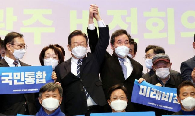 “우리는 동지” 더불어민주당 이재명 대선 후보(왼쪽 세번째)와 이낙연 전 대표가 5일 광주 서구 김대중컨벤션센터에서 열린 ‘국가비전·국민통합위원회’ 첫 회의에 참석한 뒤 손을 맞잡고 기념사진을 찍고 있다. 광주=뉴스1