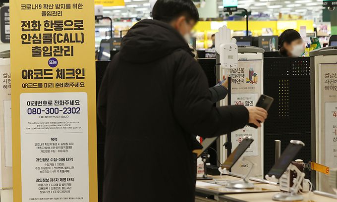 17일 서울의 한 대형마트 입구에서 시민들이 QR코드 체크를 하고 있다. 연합뉴스