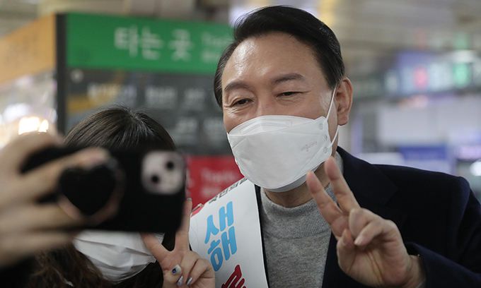 국민의힘 윤석열 대선 후보가 설 연휴 첫날인 지난 29일 서울 강남역을 찾아 시민들에게 새해 인사를 하며 기념촬영을 하고 있다. 연합뉴스