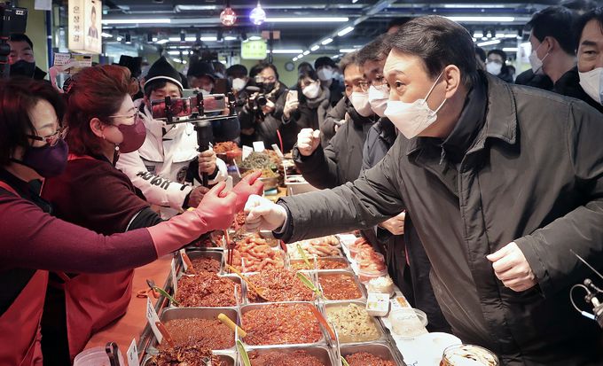 국민의힘 윤석열 대선 후보(오른쪽)가 지난 1일 인천 강화도 강화풍물시장을 방문해 상인들과 인사하고 있다. 국민의힘 선대본부 제공