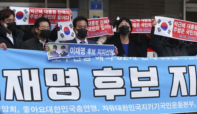 박근혜 서포터즈 중앙회 등 보수진영 애국 단체 일부 회원들이 4일 서울 여의도 더불어민주당 중앙당사 앞에서 이재명 더불어민주당 대선 후보 지지 펼침막을 들고 있다. 뉴시스