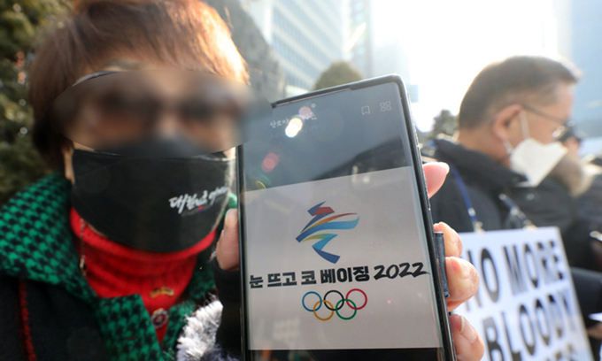 “눈 뜨고 코 베이징” 9일 서울 중구 서울중앙우체국 앞에서 나라지킴이고교연합, 자유수호포럼 등이 주최한 ‘차이나 아웃’ 집회에서 한 참가자가 베이징 동계올림픽을 비판하는 사진이 담긴 휴대전화를 들고 있다. 뉴스1