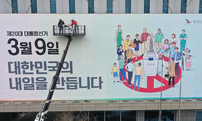 지난 7일 오후 경기도 수원시 경기도선거관리위원회에서 관계자들이 청사 외벽에 투표 참여 홍보 현수막을 설치하고 있다. 연합뉴스