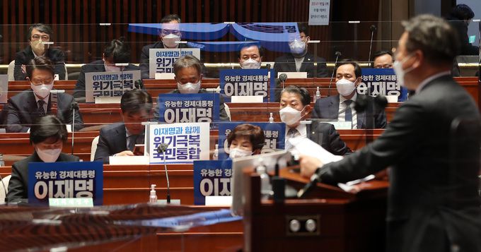 더불어민주당 윤호중 원내대표(오른쪽)가 14일 국회에서 열린 의원총회에서 모두발언하고 있다. 의원들은 각자 자리에 이재명 대선 후보 홍보 피켓을 꽂아뒀다. 허정호 선임기자