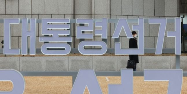 지난 14일 오전 서울 중구 한국프레스센터 마당에 설치 중인 선거 홍보 조형물 뒤로 한 시민이 지나가고 있다. 연합뉴스