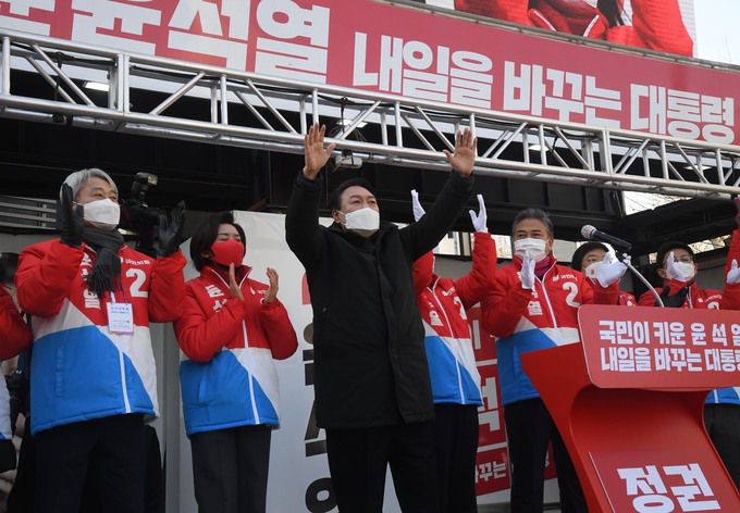 국민의힘 윤석열 대선 후보가 17일 서울 송파 잠실동 석촌호수 앞 유세에서 두손을 들어올리며 지지자들의 환호에 답하고 있다. 뉴스1