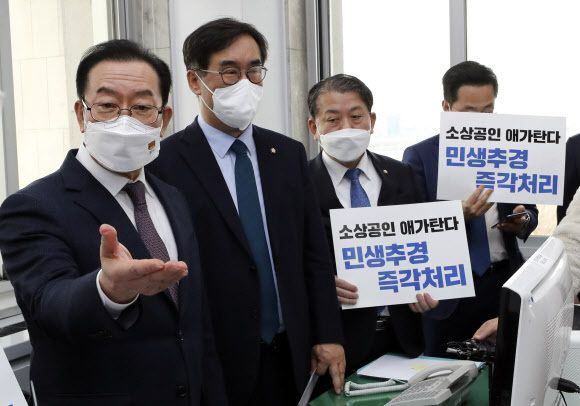 이종배 예산결산특별위원회 위원장(왼쪽)이 18일 서울 여의도 국회 예결위 위원장실에서 더불어민주당 맹성규 예결위 간사를 비롯한 여당 의원들이 추경안 처리 촉구 피켓을 들고 예결위 회의 속개를 촉구하자 발언을 하고 있다. 뉴시스