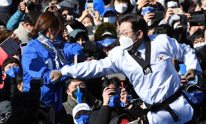 “코로나 위기 격파” 더불어민주당 이재명 대선 후보(오른쪽)가 20일 오전 경기도 수원시 만석공원에서 열린 유세에서 지지를 호소하며 태권도복을 입고 ‘코로나 위기’라고 적힌 송판을 격파하고 있다. 수원=국회사진기자단