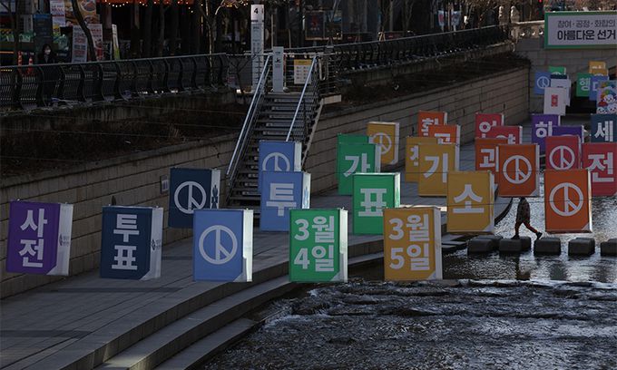 제20대 대통령선거를 열흘 앞둔 27일 청계천에 투표 독려를 위해 설치된 선거 홍보물 옆으로 시민들이 산책하고 있다. 연합뉴스