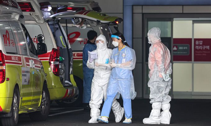 지난 17일 한 코로나19 전담병원에서 119 구급대원과 의료진이 병원에 도착한 환자를 감염병 전문 병동으로 이송하기 위해 이동하고 있다. 서울=연합뉴스