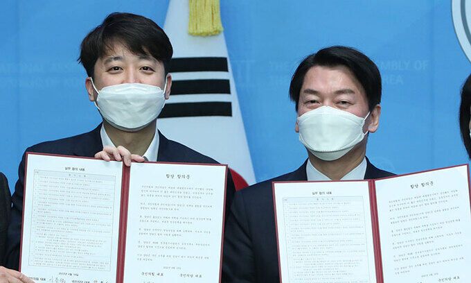 국민의힘 이준석(왼쪽), 국민의당 안철수 대표가 18일 서울 여의도 국회 소통관에서 기자회견을 열고 합당을 선언한 뒤 합의문을 들어보이고 있다. 양당은 지난 대선 과정에서 윤석열 대통령 당선인과 안 대표가 후보 단일화를 하며 내건 공동정부 기치에 따라 합당 협상을 진행해왔다. 허정호 선임기자