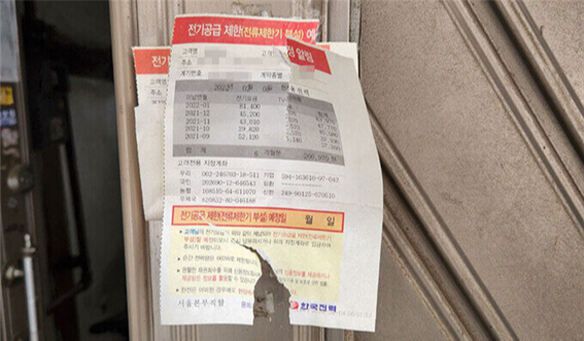 모자가 살던 창신동 주택 대문에 6개월 동안 전기요금 26만여원이 체납됐다는 안내문이 붙어 있다. 조희연 기자