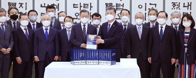 문재인 대통령이 4일 청와대에서 문재인 정부 백서 발간을 기념해 주재한 대통령 직속 국정과제위원회 관계자 초청 오찬에 앞서 조대엽 정책기획위원회 위원장으로부터 백서를 전달받고 기념촬영을 하고 있다. 연합뉴스