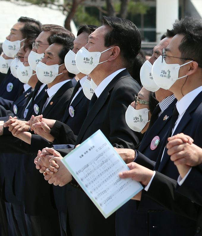 윤석열 대통령이 18일 광주 북구 국립5·18민주묘지에서 열린 제42주년 5·18민주화운동 기념식에서 참석자들과 손을 잡은 채 '임을 위한 행진곡'을 제창하고 있다.    대통령실사진기자단