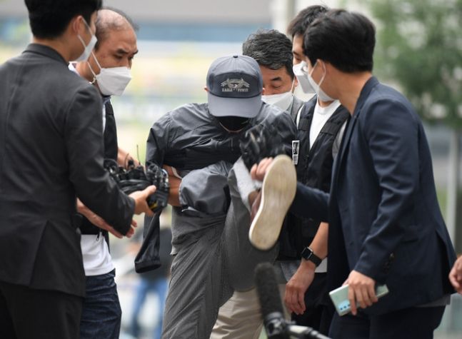 위치추적 전자장치(전자발찌)를 훼손하고 여성 2명을 살해한 혐의를 받는 강윤성(56)이 2021년 8월 31일 서울 송파구 서울동부지법에 구속 전 피의자 심문(영장실질심사)을 받으러 가다 취재진을 향해 발길질을 하고 있다. 남정탁 기자