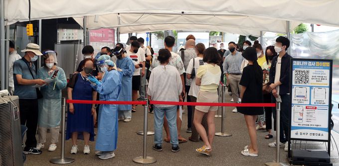 코로나19 확산세가 지속된 18일 오후 서울 강서구보건소 선별진료소에서 시민들이 코로나19 검사를 받기 위해 길게 줄지어 서 있다. 뉴시스