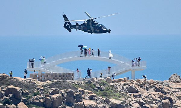 4일 중국에서 대만과 가장 가까운 푸젠성 핑탄섬에서 중국 군용 헬기가 관광객들 위로 날아가고 있다. 핑탄=AFP연합뉴스