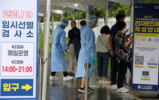 11일 오후 광주 서구 5·18민주화운동 교육관에 재설치 운영에 들어간 임시선별검사소에서 의료진이 코로나19 검사를 받으려는 시민들의 문진표 작성을 돕고 있다. 광주=연합뉴스