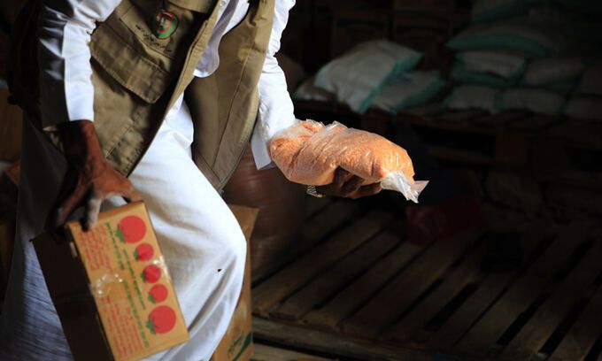 지난 14일 예멘 북부 사다 지방의 한 배급소에서 구호요원이 예멘인들에게 식량 배급품을 나눠주고 있다.사다=EPA연합뉴스