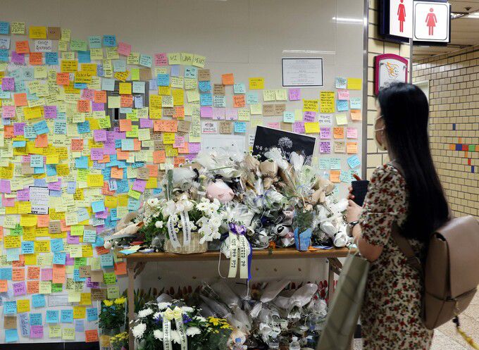 지난 14일 서울교통공사 역무원 스토킹 살인사건이 발생한 서울 지하철 2호선 신당역 여자화장실 앞에 마련된 추모공간에서 18일 오전 한 시민이 추모하고 있다.