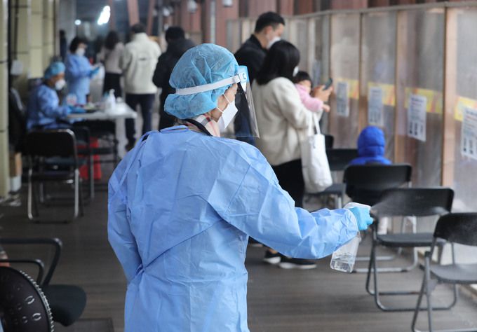22일 서울 송파구보건소에 마련된 코로나19 선별진료소에서 의료진이 소독을 하고 있다. 중앙방역대책본부에 따르면 이날 0시 기준 코로나19 신규 확진자는 7만 2,873명으로 전주 동일(7만 2,883명) 대비 10명 줄었다.    뉴스1